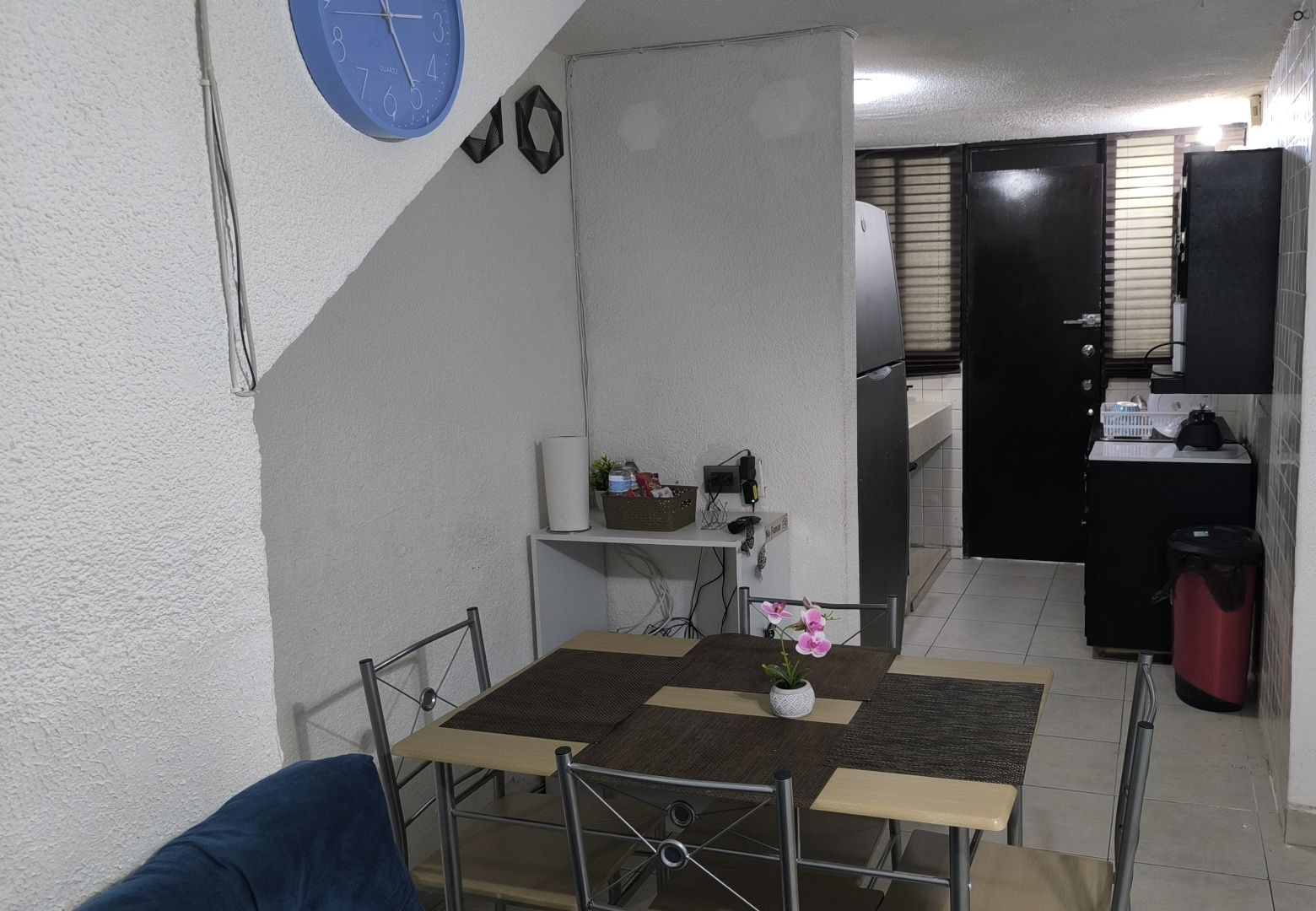 El Loft donde se ve el comedor, la cocina, el baño y la puerta de entrada
