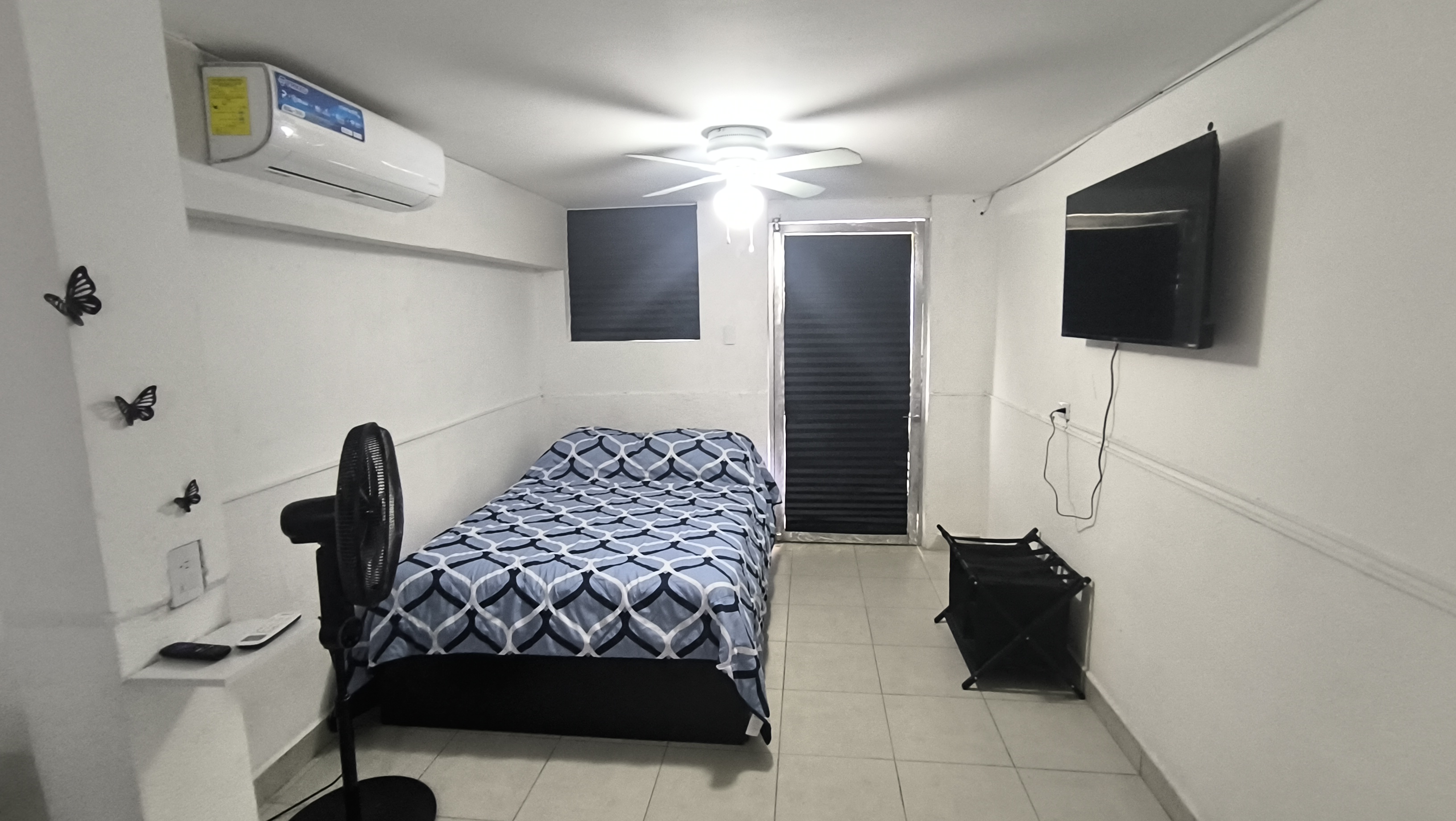 El cuarto 3 del Loft donde se ve el sillón, el ventilador, la cama, la tele y el aire acondicionado